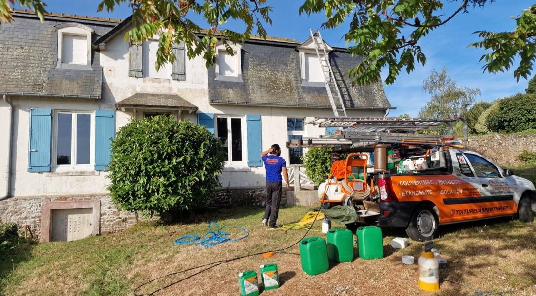Camion Toiture Carpentier garé devant une maison, toiture en ardoise